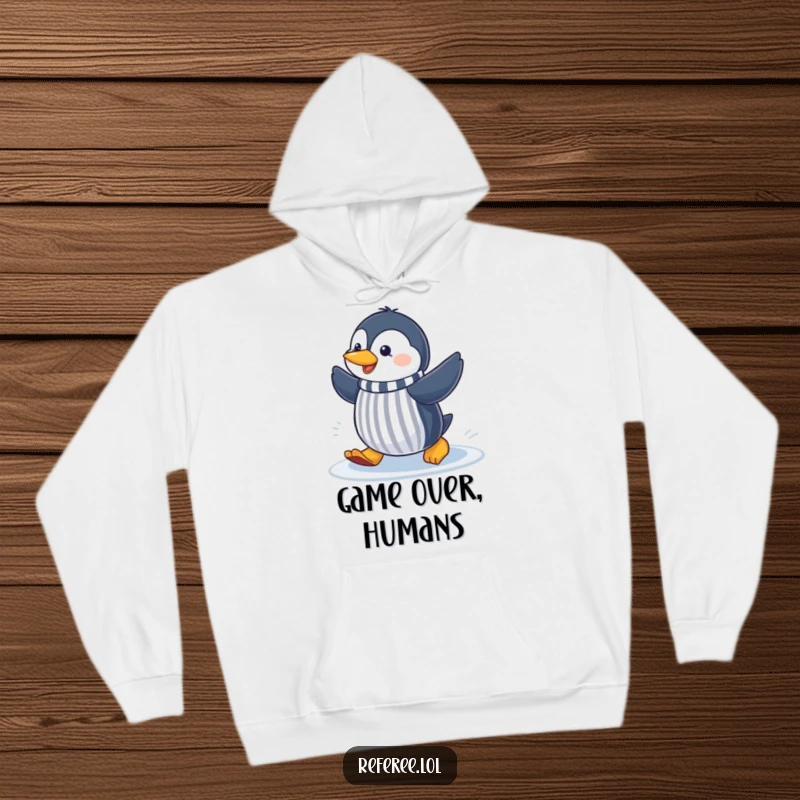 Funny cheerful penguin sliding on ice, signaling like a referee, featured on a cozy hoodie for humorous warmth.